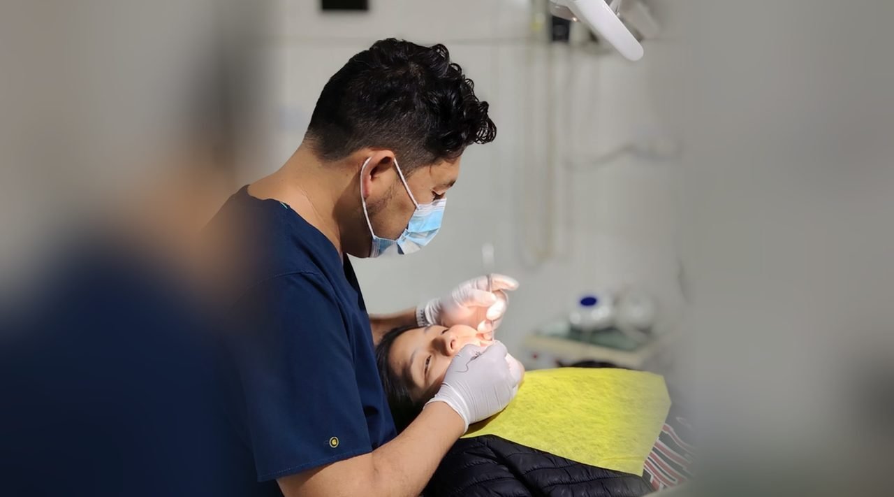 El Dr. Adhemar Campos Reynaga atendiendo a una paciente en el Consultorio Odontológico Santa María